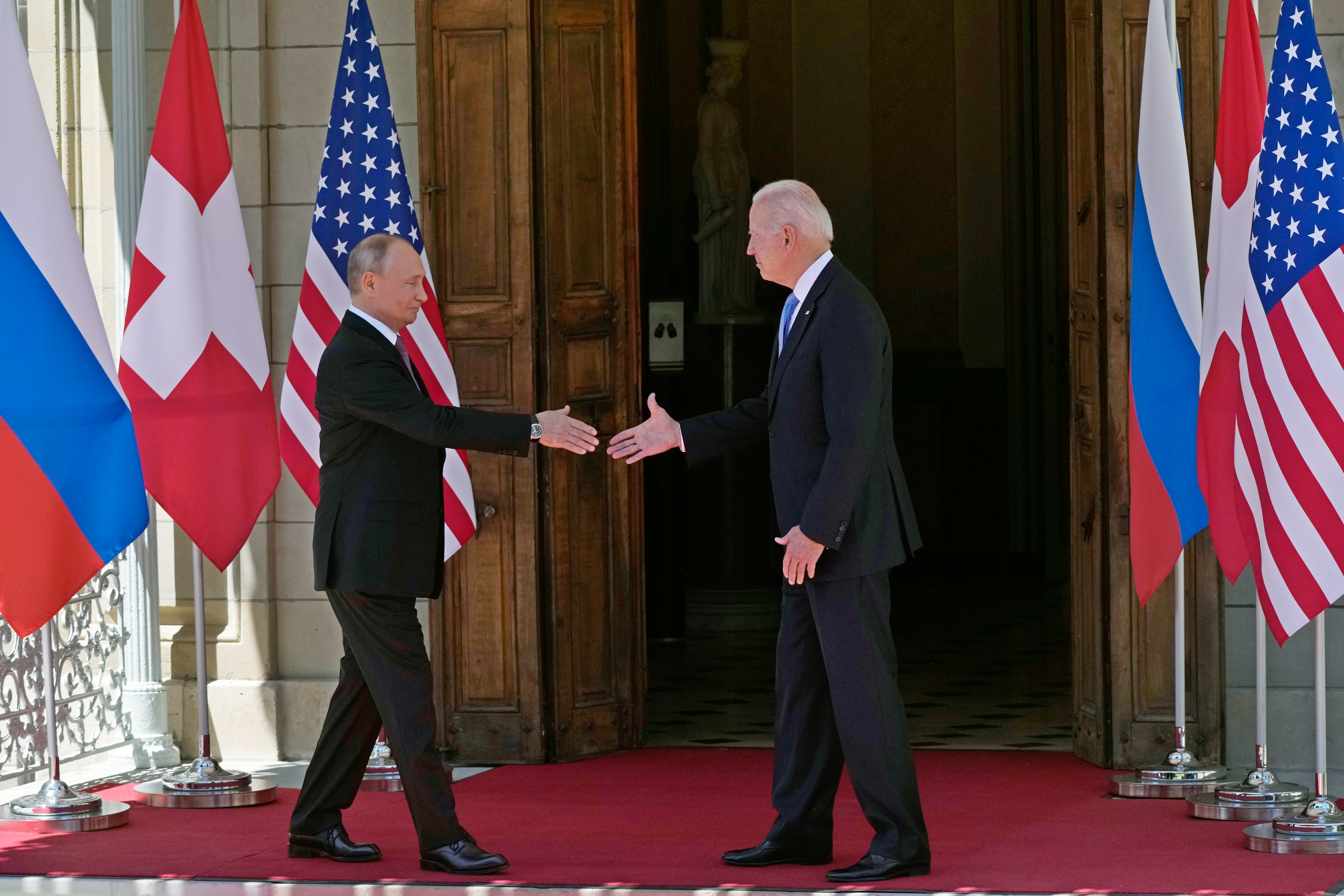 Пунктуальность, двойное рукопожатие и шутка: встреча Байдена и Путина в фотографиях